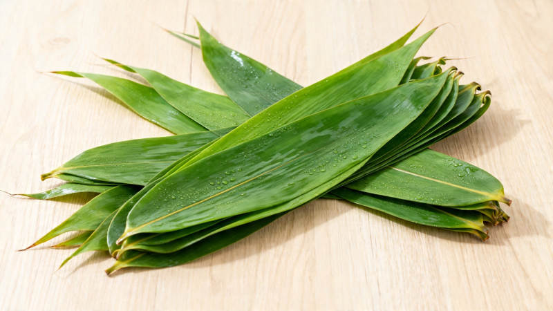 新鲜粽叶堆叠木板上图片