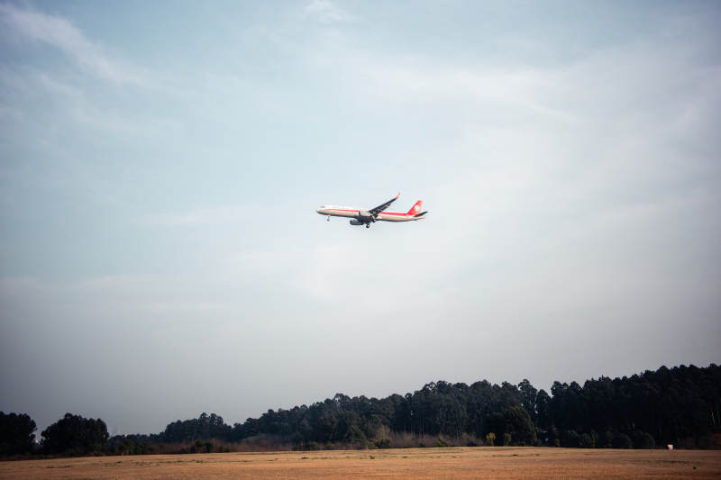 飞机低空飞过田野上空图片