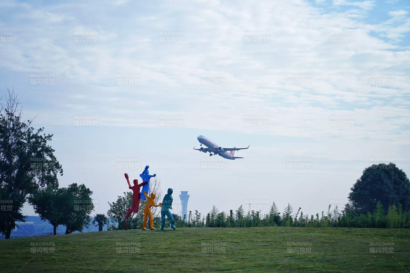 飞机掠过彩色雕塑上空图片