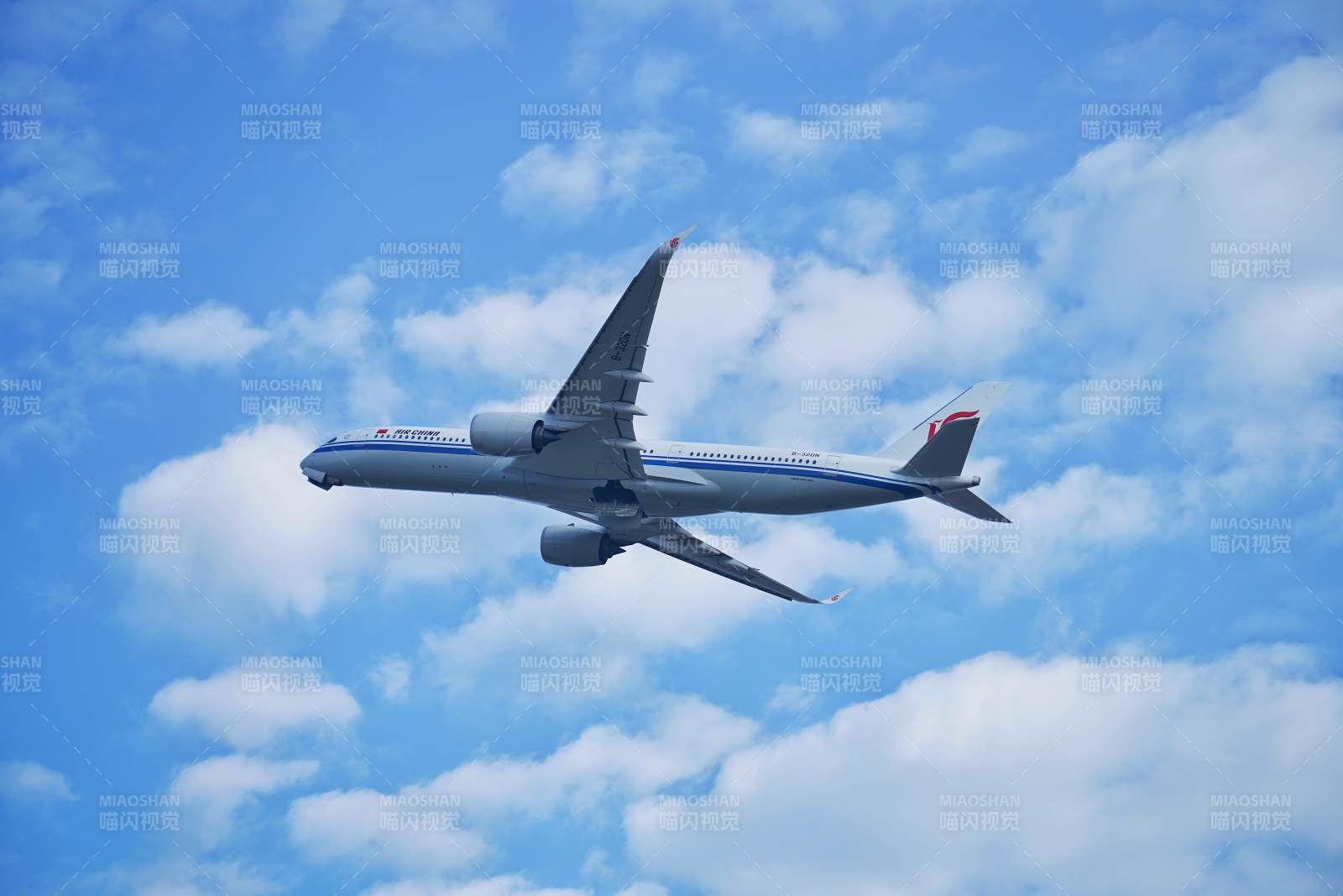 客机翱翔蓝天白云间图片