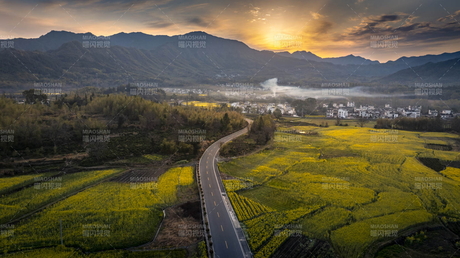 油菜花田伴山路 晨曦映远山图片