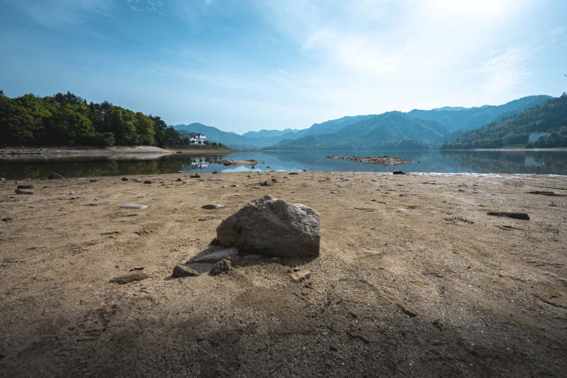 湖岸干涸 巨石孤影映青山图片