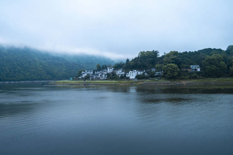 雾锁青山白墙村落静湖旁图片