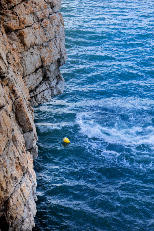 崖边黄球浮蓝海图片