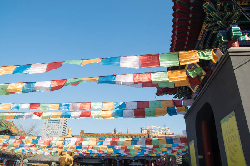 彩旗飘扬古寺蓝天映衬图片