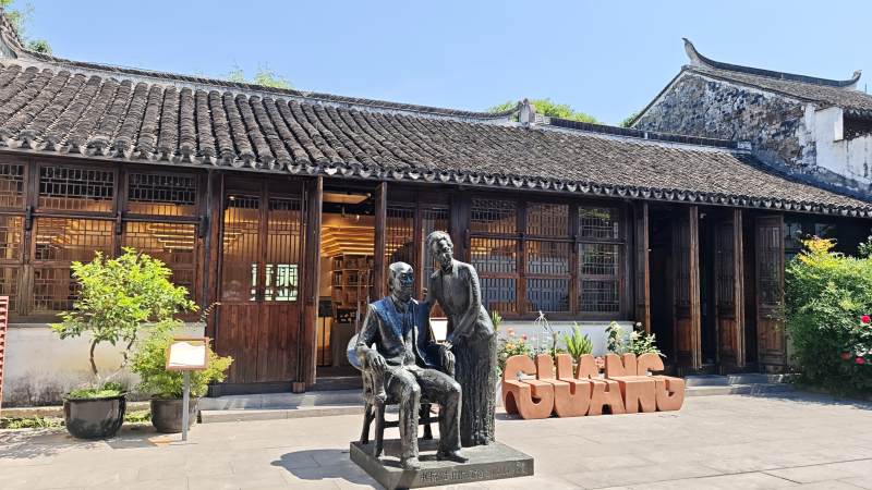 江南古宅前的铜像雕塑图片