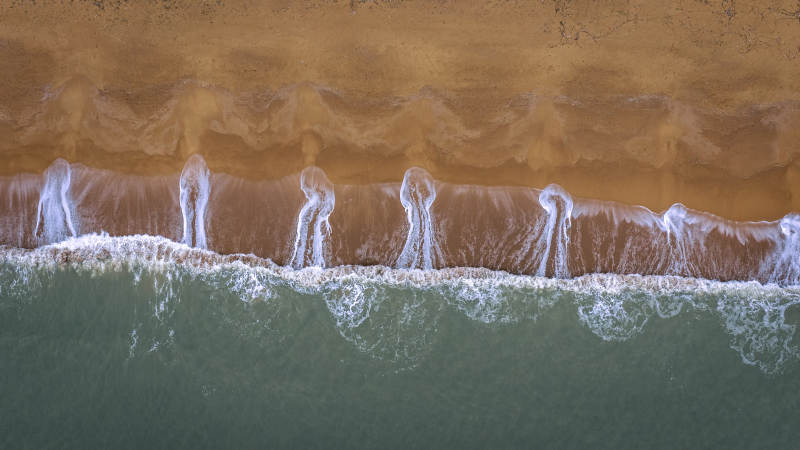 海浪轻抚沙滩 泡沫如画图片