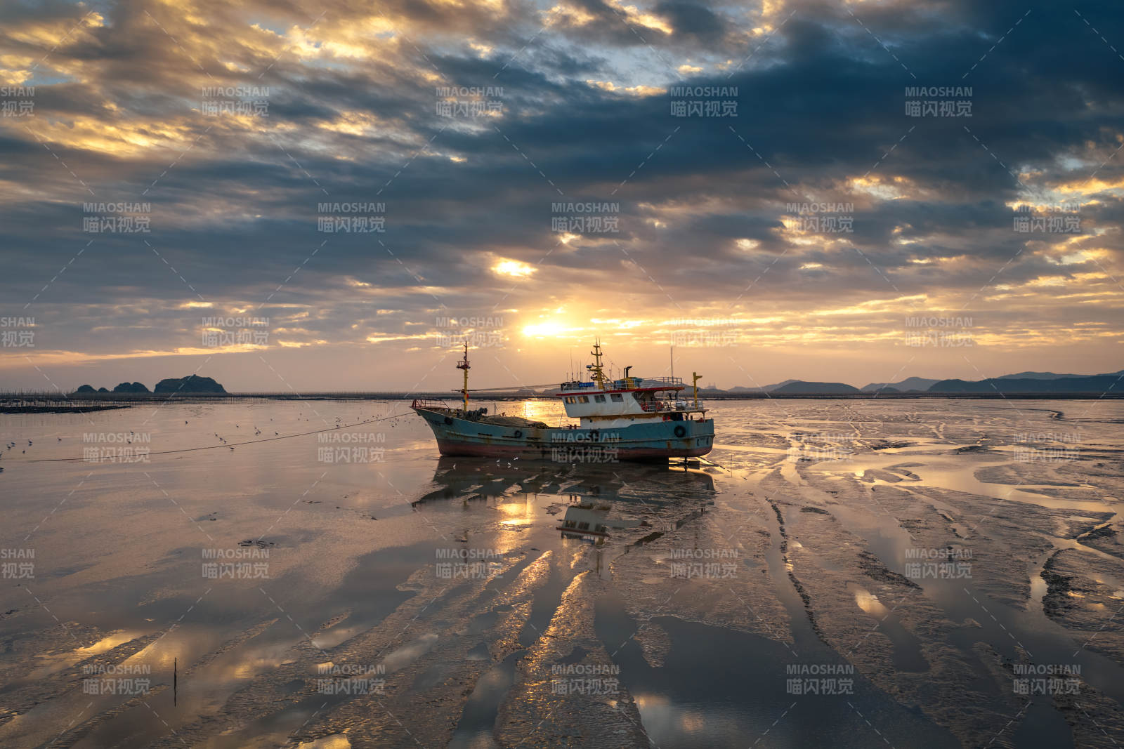 夕阳渔船静泊滩涂图片