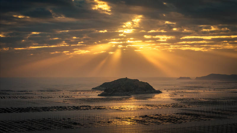 夕阳穿云 金辉洒海岛图片