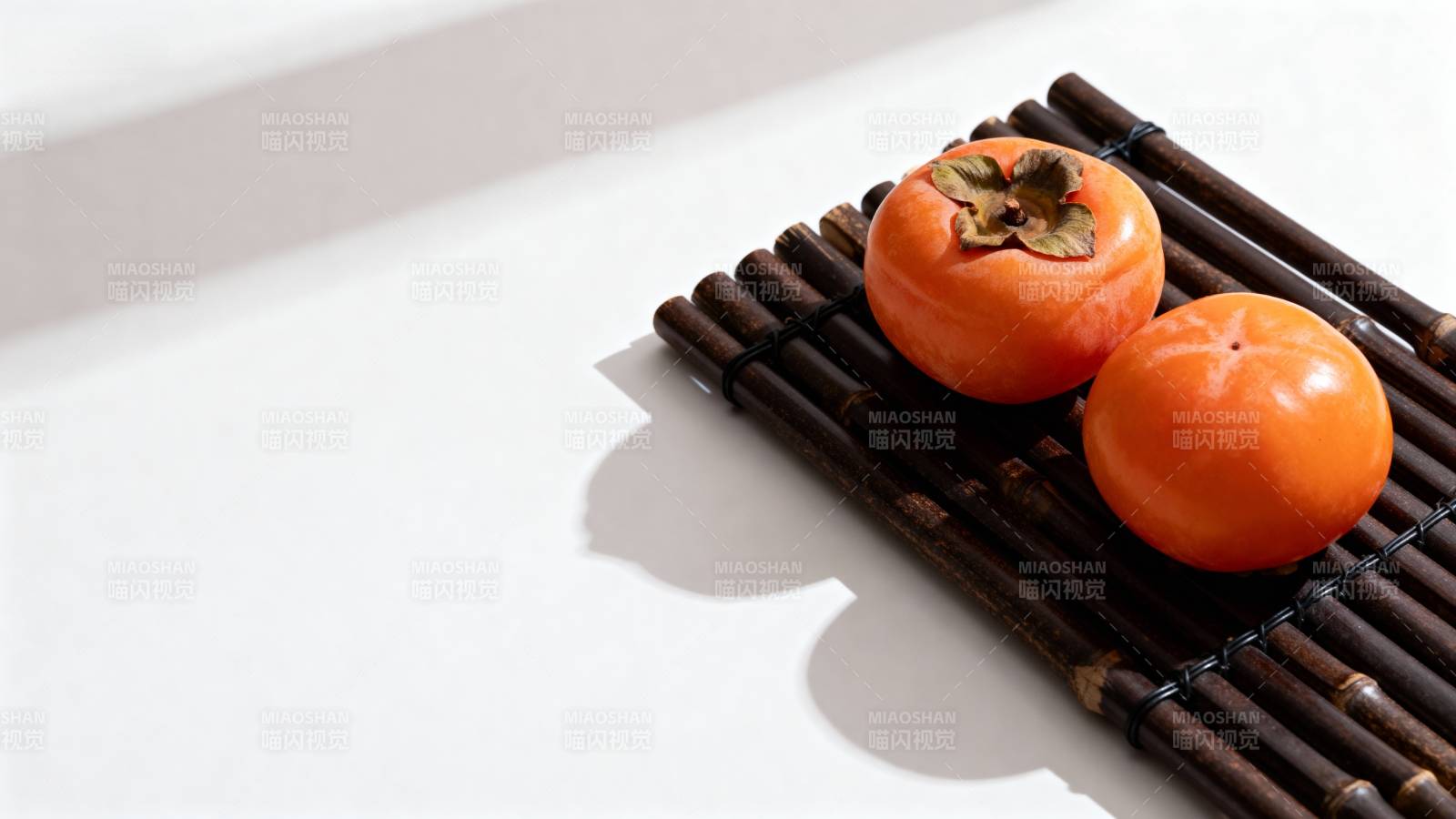 竹席上的两颗柿子图片