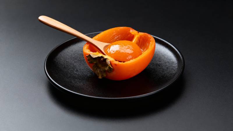 黑盘橙柿配木勺图片