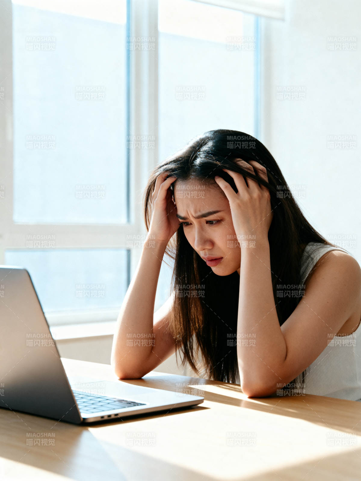 电脑前焦虑的年轻女子图片