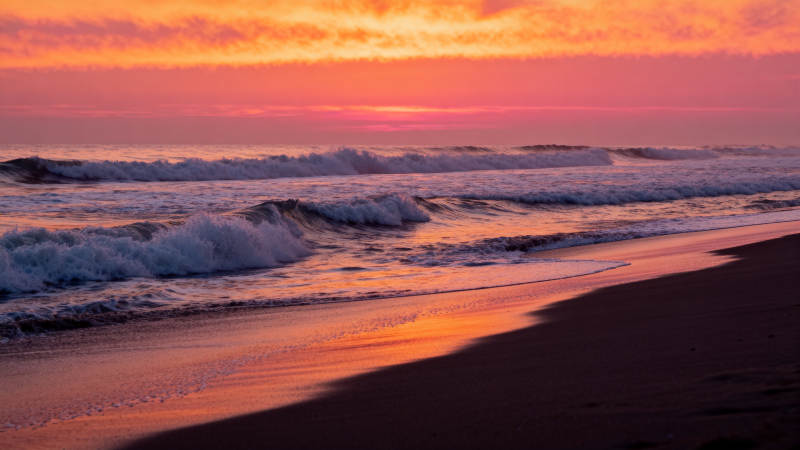 夕阳染海 浪吻沙滩图片