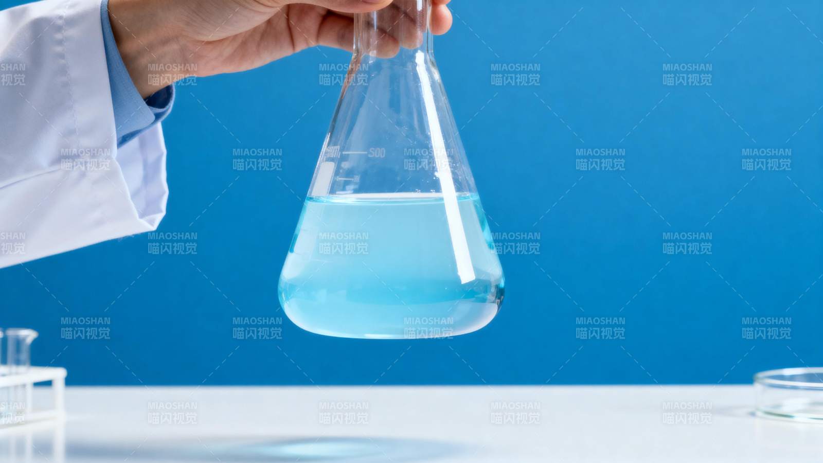 科学家手持蓝色溶液锥形瓶图片