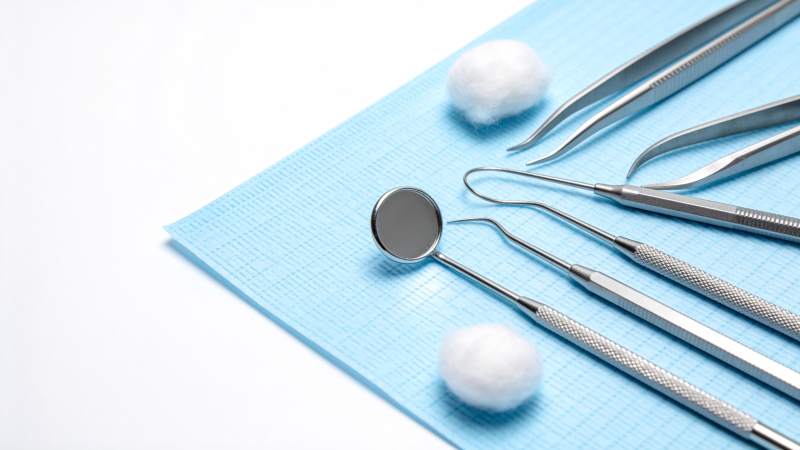 牙科工具整齐摆放于蓝垫上图片