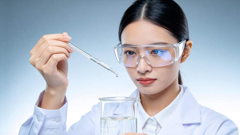 女科研人员用滴管向烧杯滴加液体图片