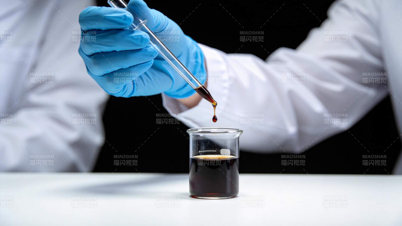 实验人员用滴管向烧杯滴加深色液体图片