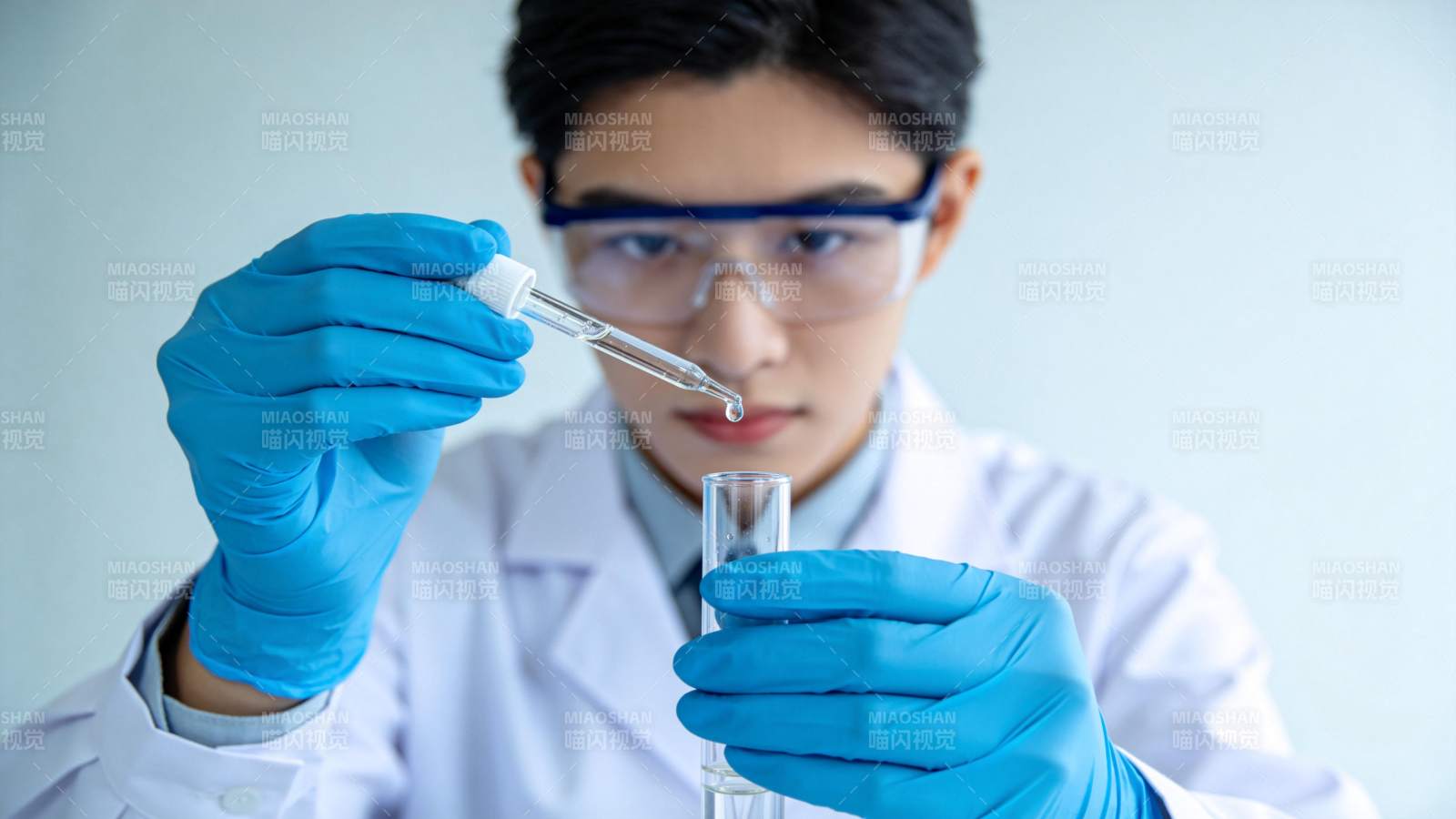 科研人员佩戴护目镜用滴管向试管滴加液体图片