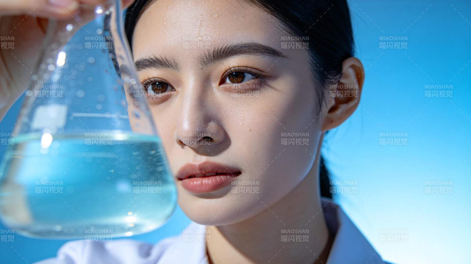 女科学家专注观察蓝色溶液图片