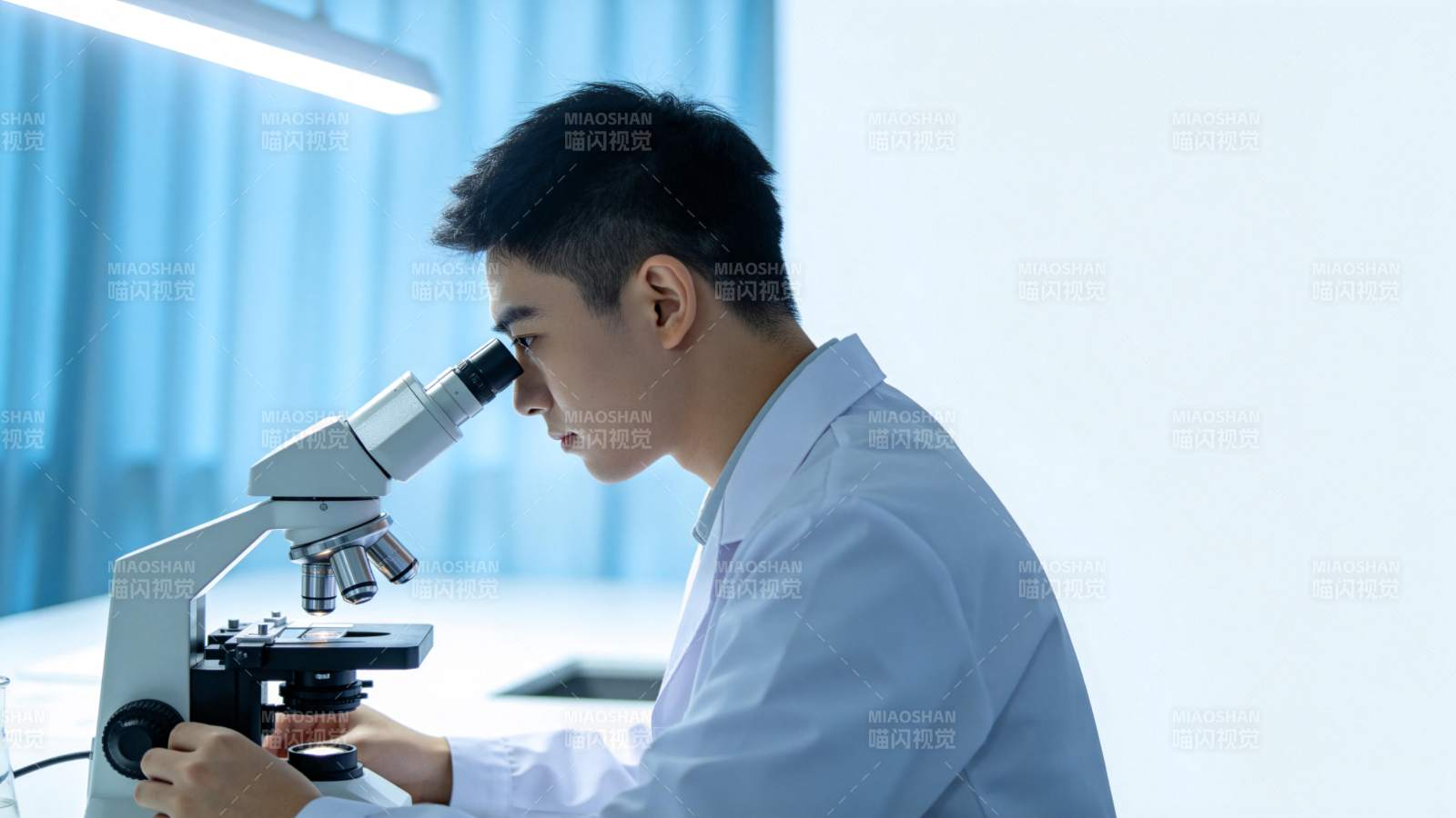 青年科学家专注显微镜观察图片