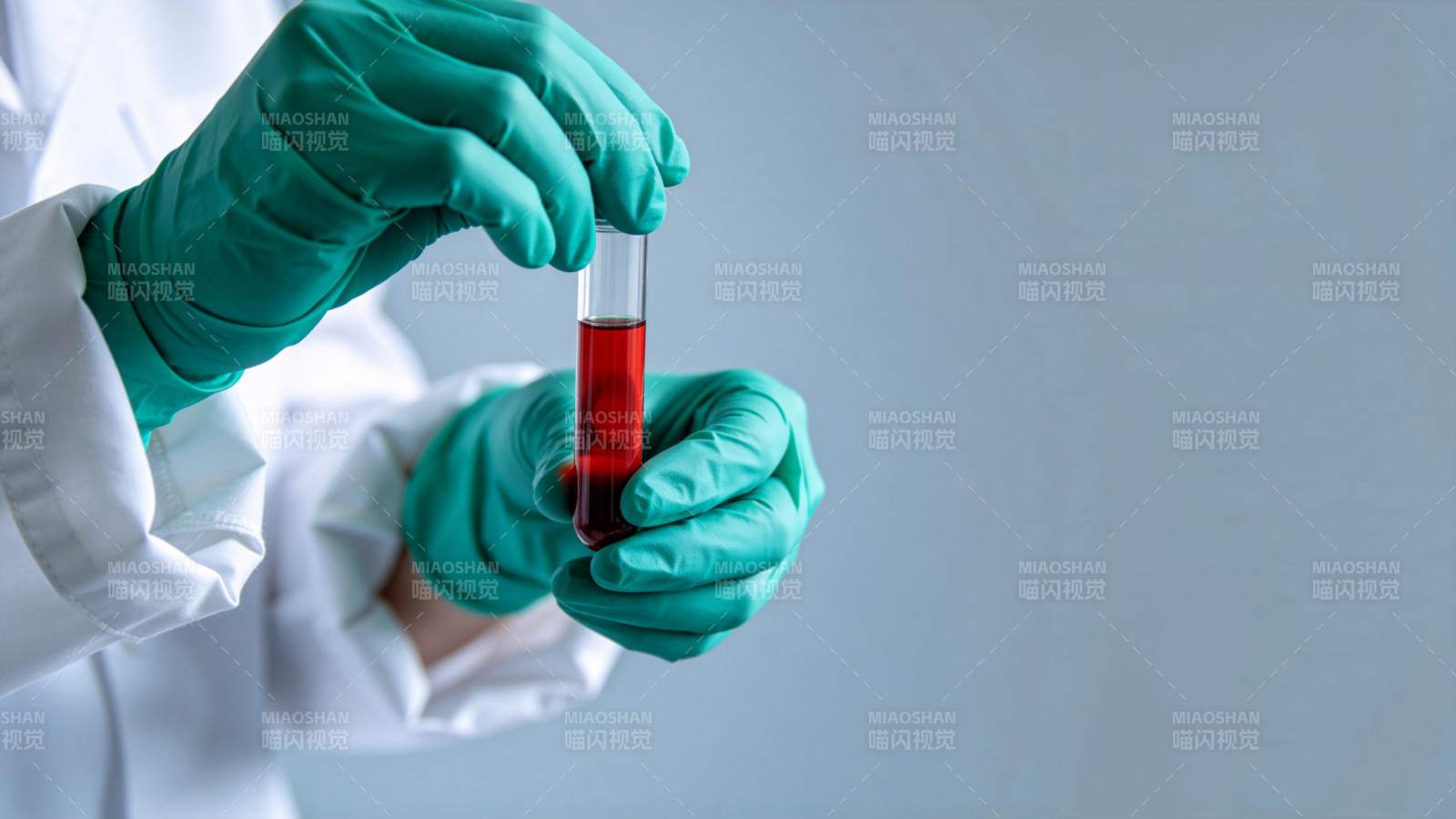 戴绿手套持红色液体试管图片