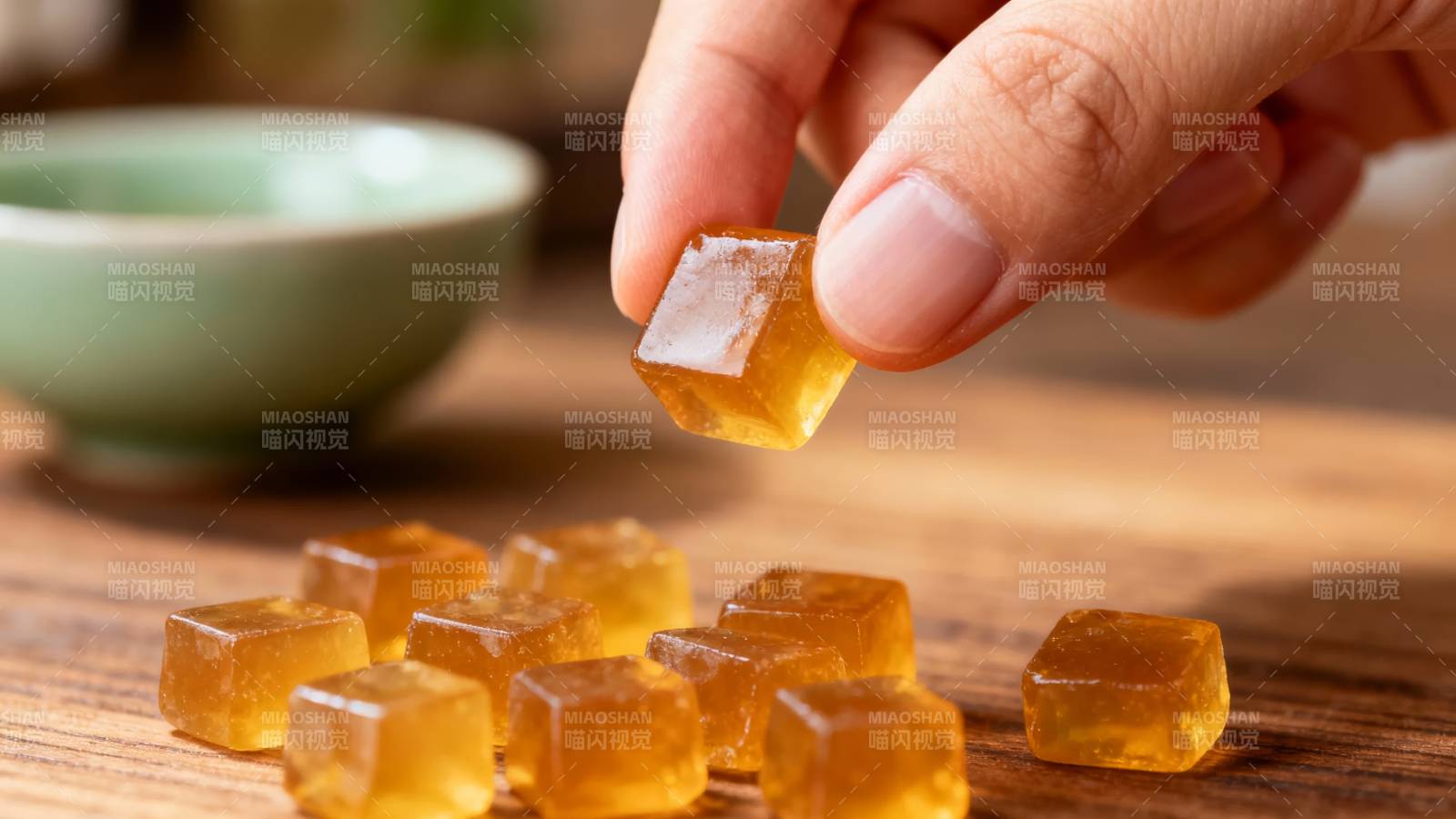 手握琥珀糖 木桌散金块图片