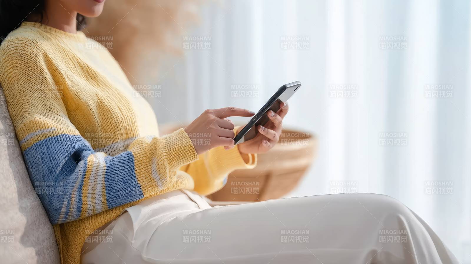 黄蓝毛衣女坐沙发玩手机图片