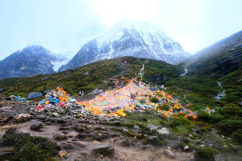雪山下的彩色经幡堆图片