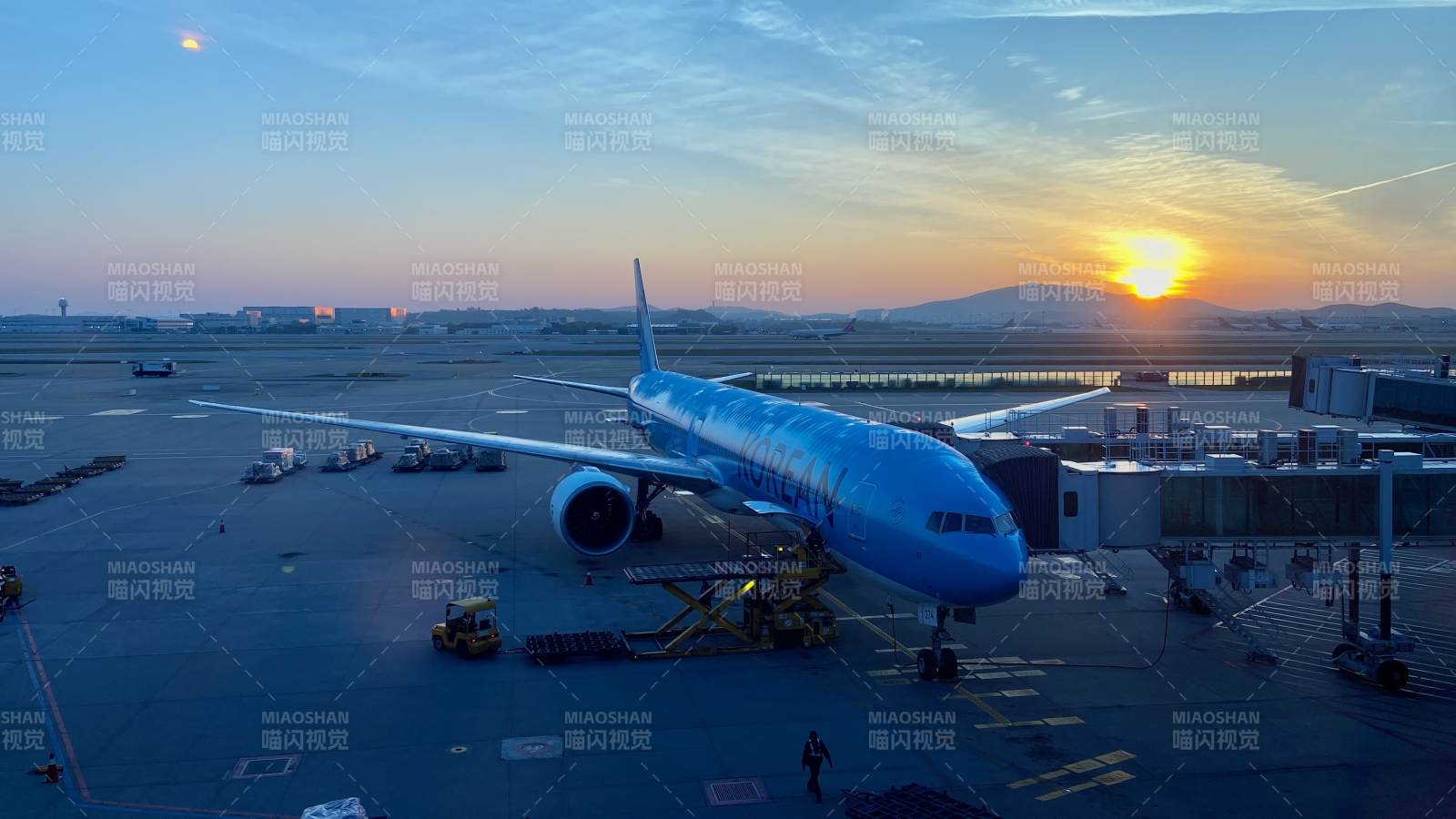 夕阳下的蓝色客机停机坪图片