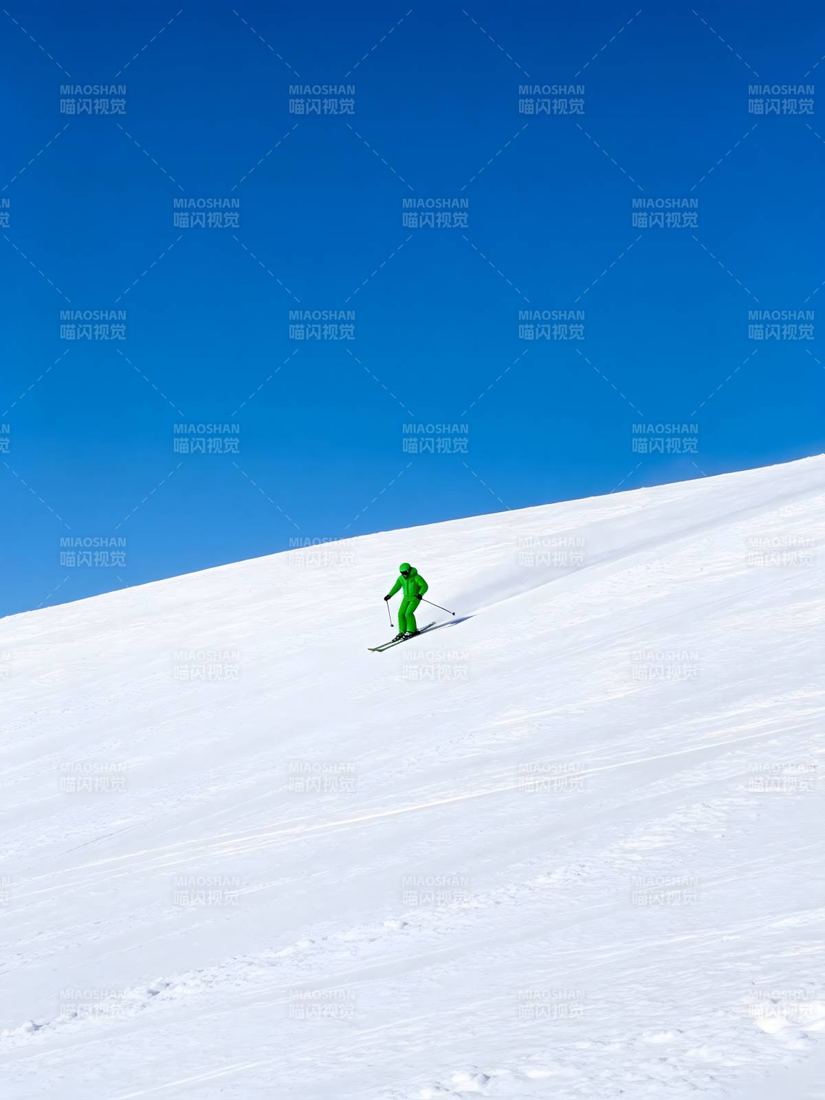 绿衣滑雪者驰骋雪坡图片