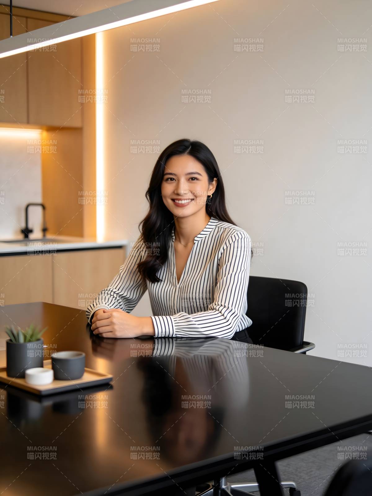 微笑女职员坐于现代办公桌前图片