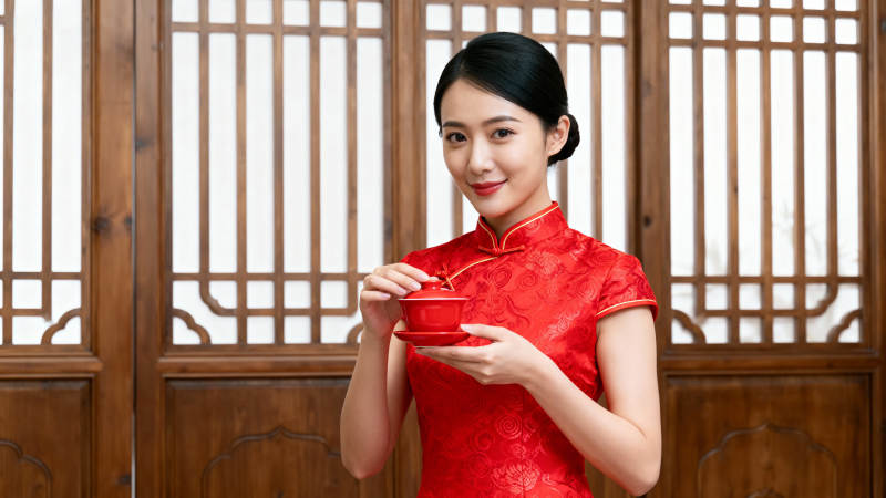 旗袍女子捧茶微笑图片