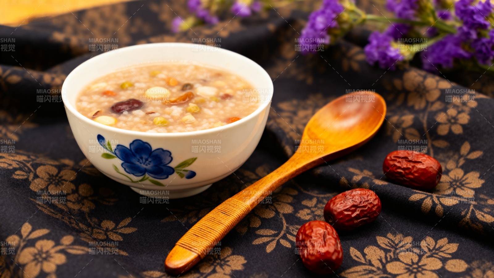 养生粥配红枣木勺花布景图片
