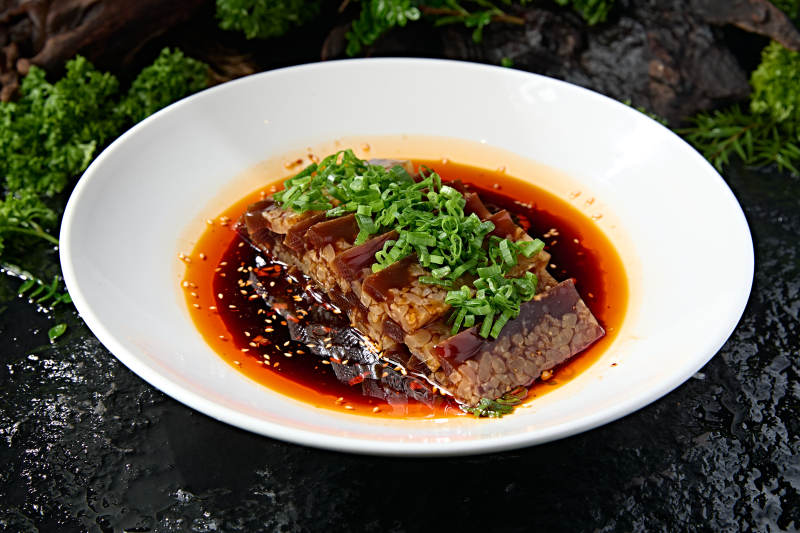 白圆盘装手工切块肉皮冻浇红辣油图片