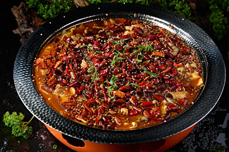 黑色锤纹铁盆装的正宗川味水煮鱼片图片