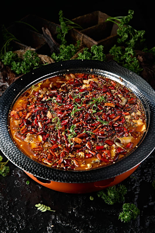 黑色锤纹铁盆装的正宗川味水煮鱼片图片