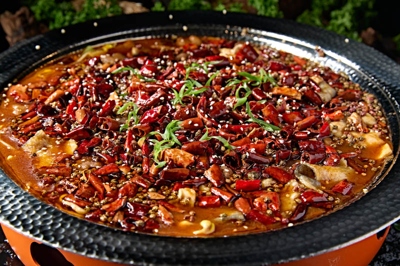 黑色锤纹铁盆装的正宗川味水煮鱼片图片