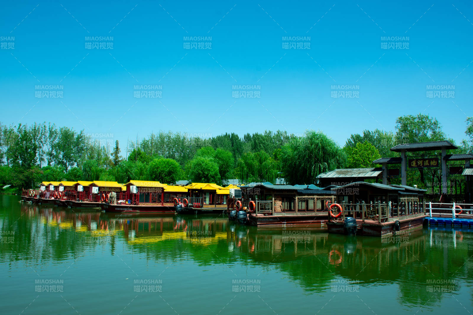 台儿庄运河湿地湖上画舫映绿树蓝天图片