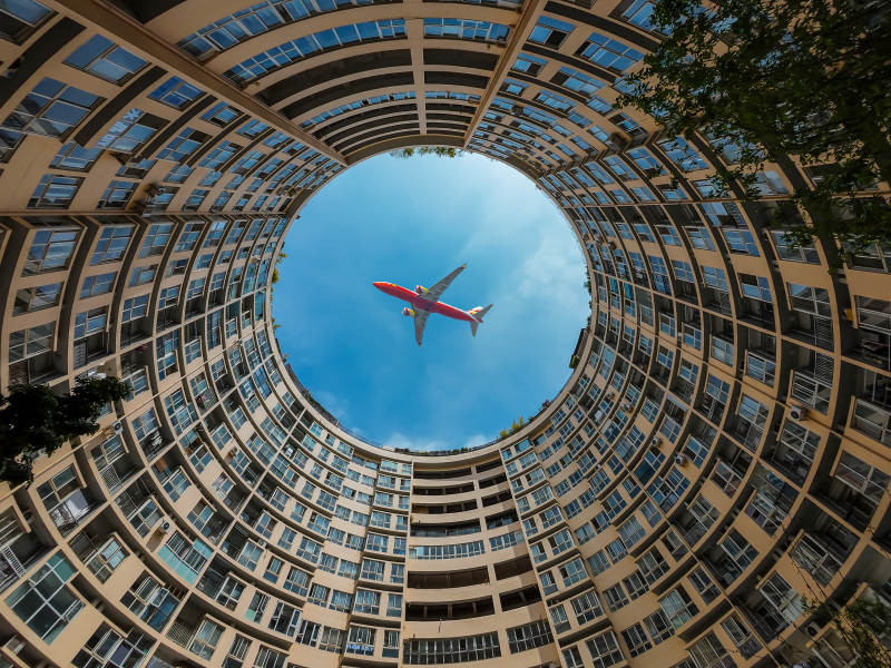 楼间圆空 飞机掠蓝天图片