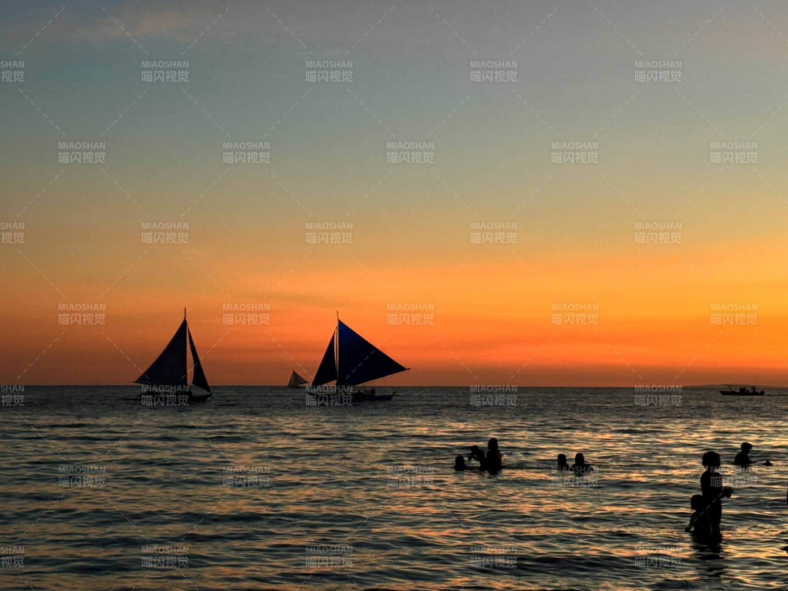 夕阳帆船 海中嬉戏人影图片