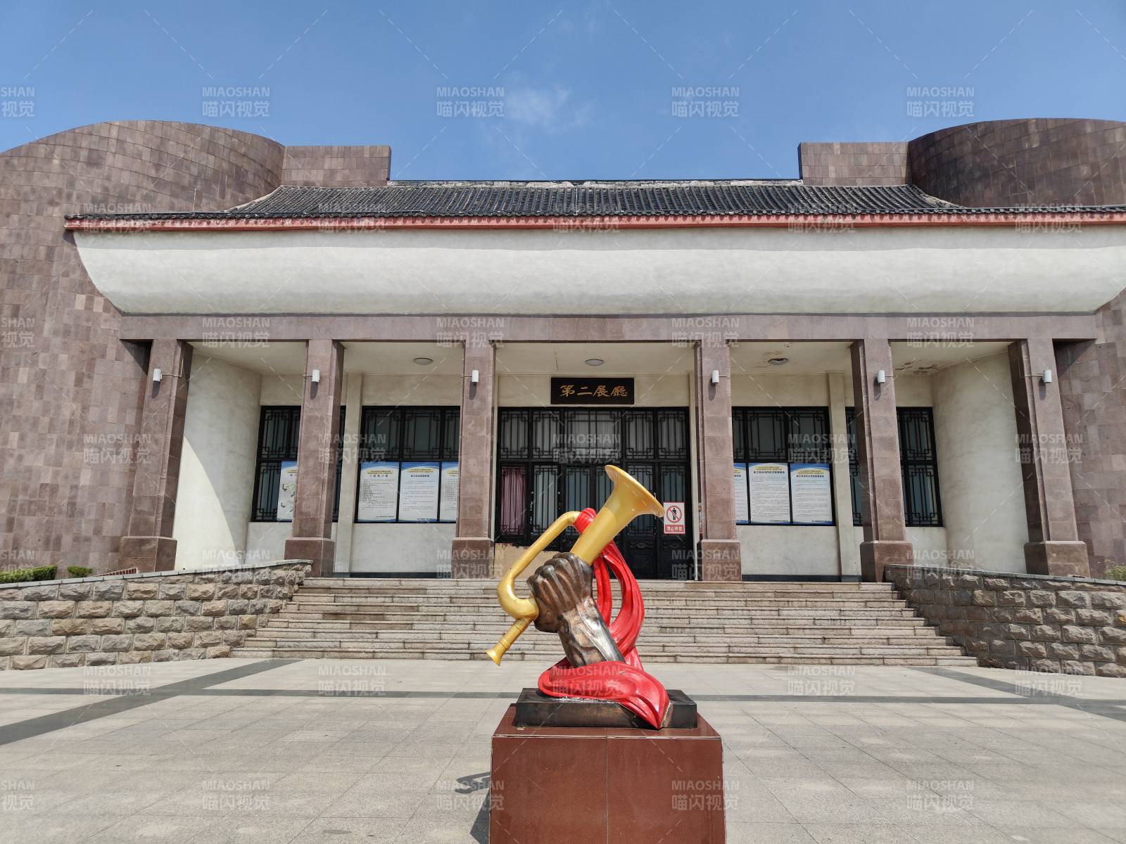 红色雕塑前的纪念馆建筑图片