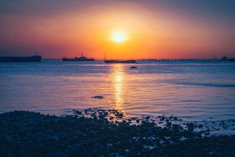 夕阳映海 船影静泊图片