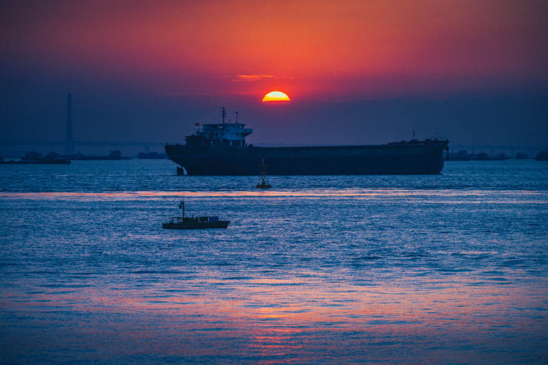 夕阳下的货轮剪影图片