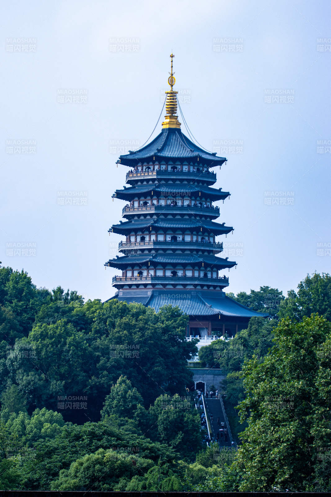 雷峰塔矗立绿树丛中图片