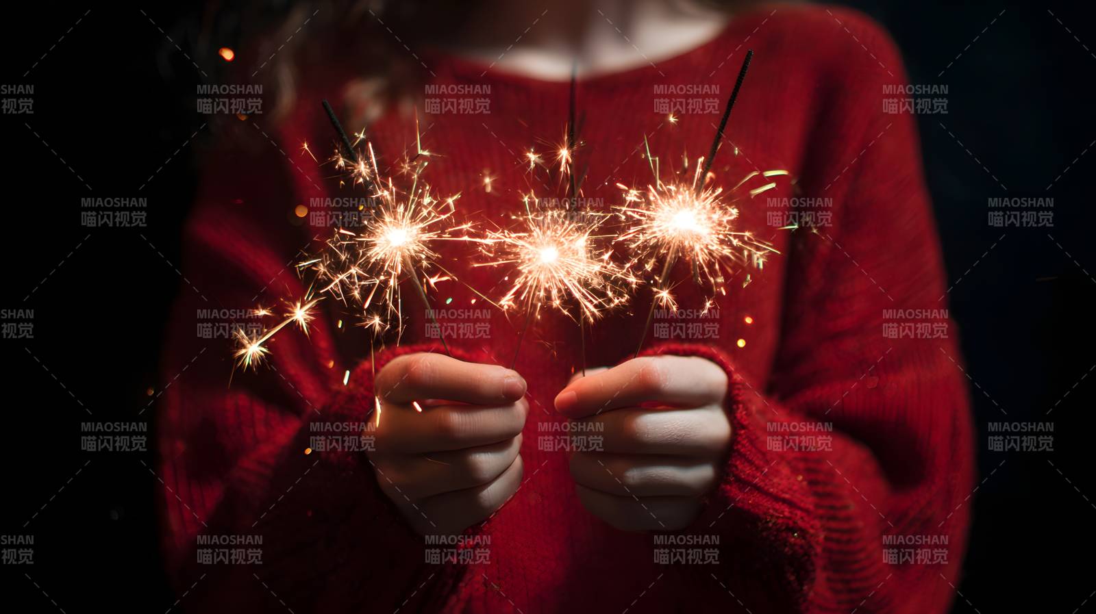 红毛衣握 sparklers 温暖夜图片