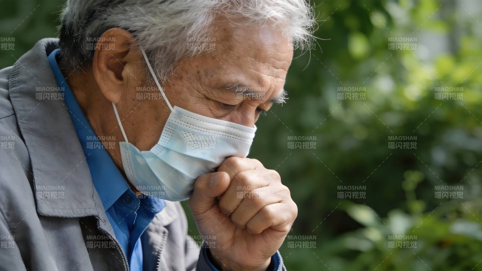 老人戴口罩咳嗽 户外绿植背景图片
