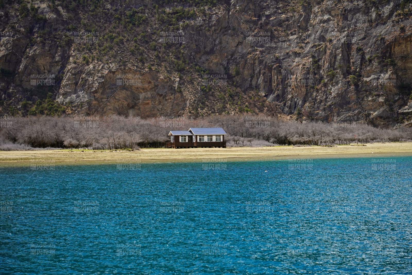 湖岸孤屋映山崖。图片