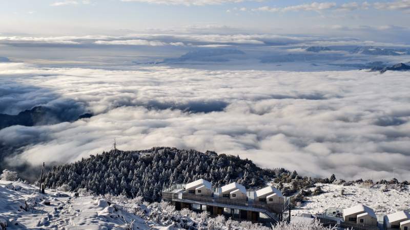 雪山云海上的小屋群图片