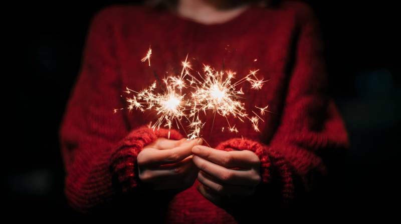 红毛衣握 sparkler 温暖夜图片