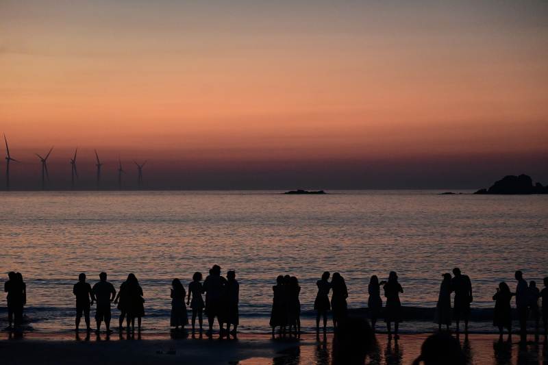 夕阳海边人影风车剪影图片
